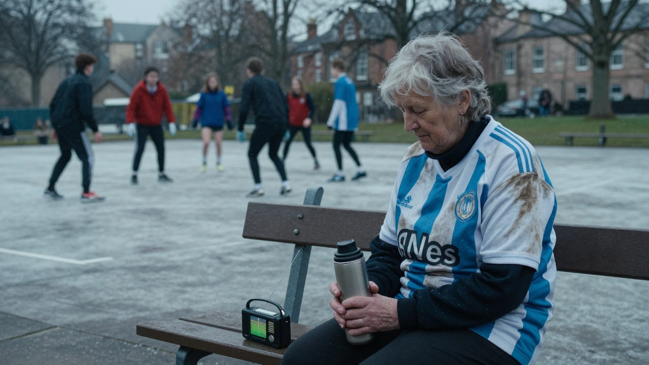An elderly woman in a football jersey watches a match on a radio in the snow.